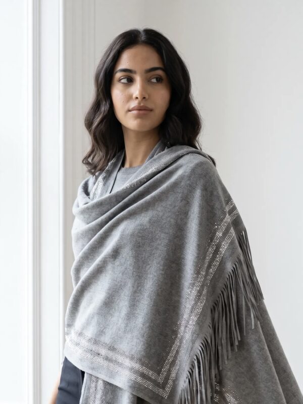 Pure Cashmere Fabric – Crafted from premium-grade cashmere, offering exceptional softness, warmth, and lightweight comfort Swarovski Embellishment – Delicately adorned with subtle Swarovski crystal detailing for an elegant, refined shimmer Suede Fringe Finish – Finished with rich suede fringes, adding texture and a sophisticated edge Generous Size – Measures 200 x 70 cm, perfect for versatile styling as a wrap, stole, or shawl Timeless Neutral Tone – A classic earthy shade that complements both formal and casual ensembles Artisan Craftsmanship – Expertly finished to ensure durability and a luxurious drape