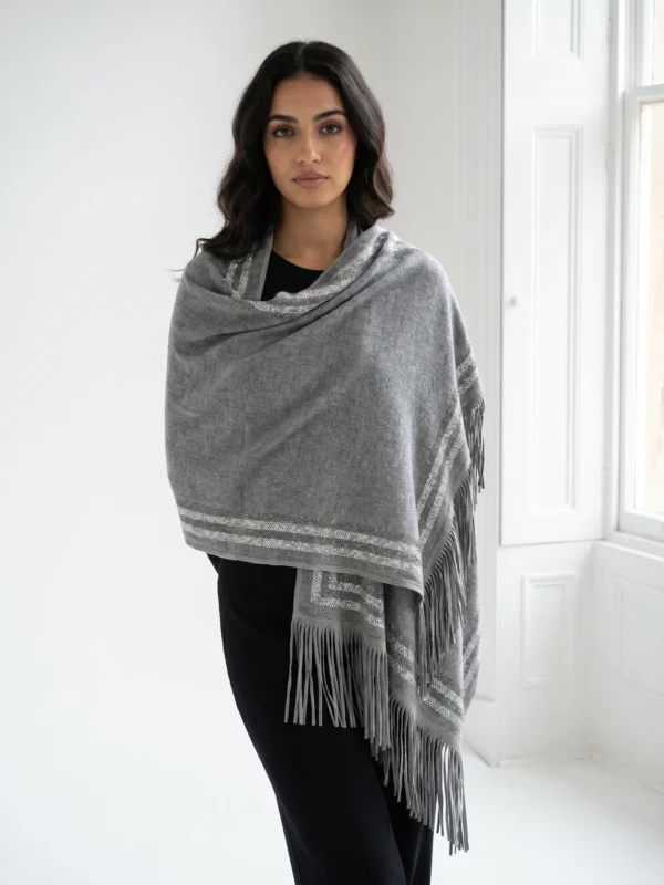 Pure Cashmere Fabric – Crafted from premium-grade cashmere, offering exceptional softness, warmth, and lightweight comfort Swarovski Embellishment – Delicately adorned with subtle Swarovski crystal detailing for an elegant, refined shimmer Suede Fringe Finish – Finished with rich suede fringes, adding texture and a sophisticated edge Generous Size – Measures 200 x 70 cm, perfect for versatile styling as a wrap, stole, or shawl Timeless Neutral Tone – A classic earthy shade that complements both formal and casual ensembles Artisan Craftsmanship – Expertly finished to ensure durability and a luxurious drape
